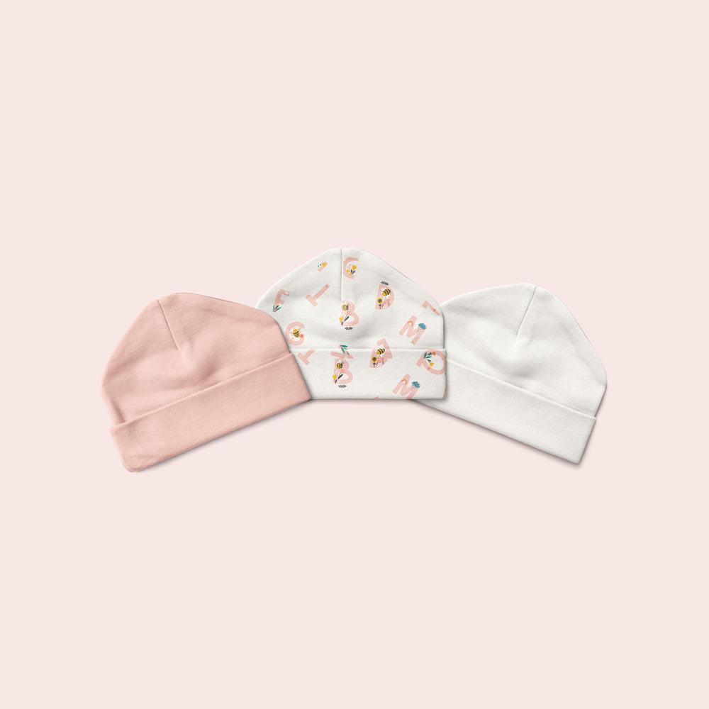 Three baby beanies in pink, pink alphabet print, and white.