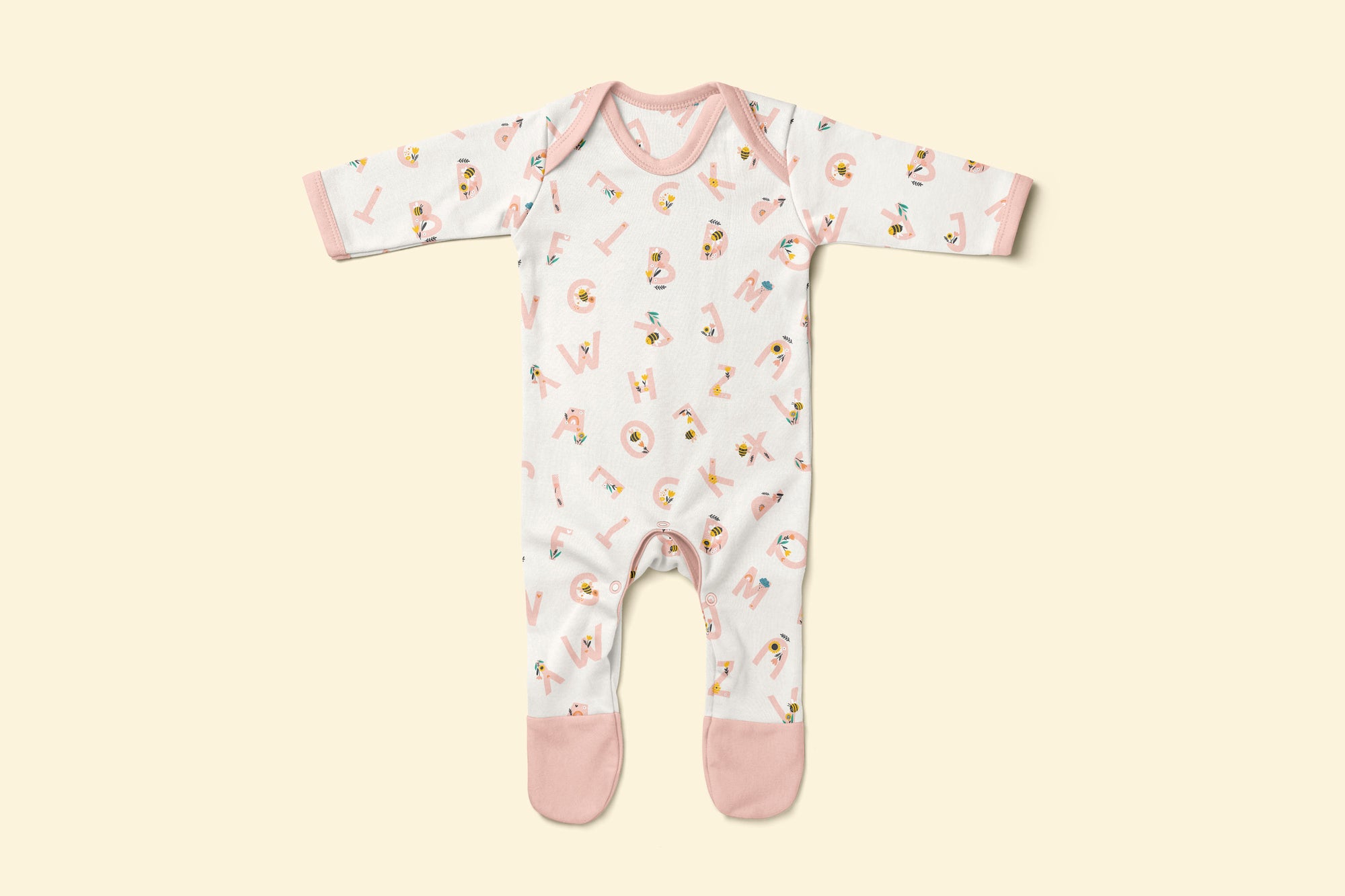 Baby rompersuit with pink alphabet pattern and pink accents